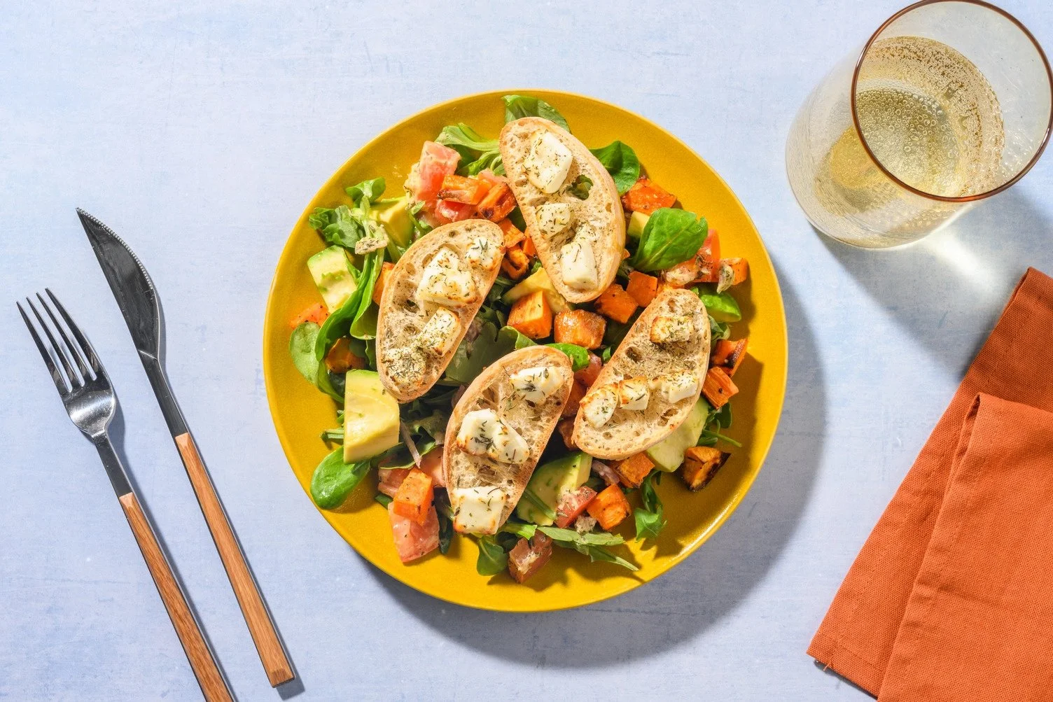 Salad of avocado and goat cheese toast with honey, sweet potato, and roasted tomatoes